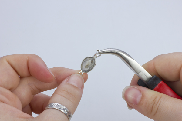 Krok 16.Rozgięte kółeczko zaciskowe przełóż przez oczko znajdujące się w przekładce w okuciu z kamieniem