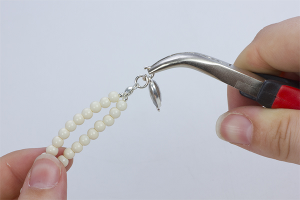 Krok 16.Rozgięte kółeczko zaciskowe przełóż przez oczko znajdujące się w przekładce w okuciu z kamieniem