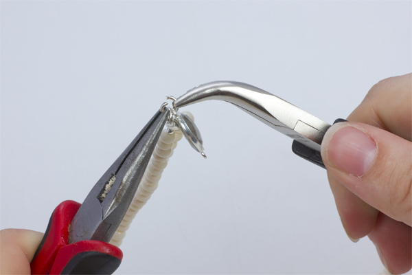 Krok 16.Rozgięte kółeczko zaciskowe przełóż przez oczko znajdujące się w przekładce w okuciu z kamieniem