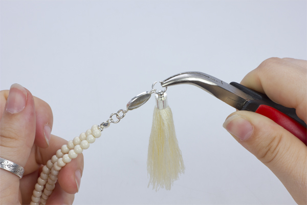 Krok 20. Przekładamy kółeczko z chwostem przez drugie oczko przekładki